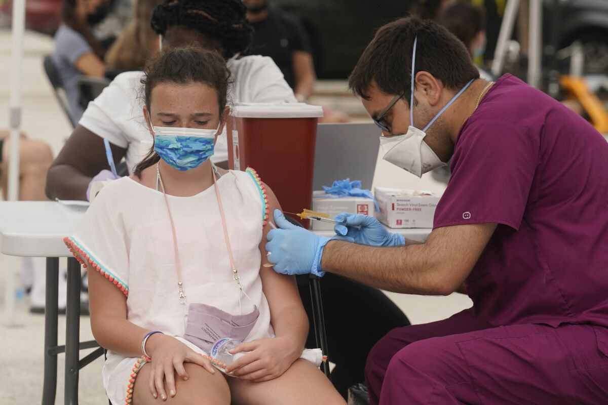FILE - Francesca Anacleto, 12, receives her first Pfizer COVID-19 vaccine shot from nurse Jorge Tase, Wednesday, Aug. 4, 2021, in Miami Beach, Fla. In most states, minors need the consent of their parents in order to be vaccinated against COVID-19. Navigating family politics in cases of differing views has been a challenge for students and organizers of outreach campaigns, who have faced blowback for directly targeting young people. (AP Photo/Marta Lavandier, File)