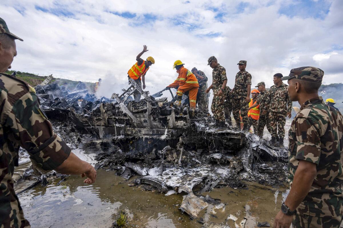 Nepal army personnel sort through debris after a domestic plane crashed in Kathmandu, Nepal.