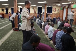 FILE - Yusuf Abdulle, standing, director of the Islamic Association of North America, prays with fellow Muslims at the Abubakar As-Saddique Islamic Center in Minneapolis on Thursday, May 12, 2022. Minneapolis will allow broadcasts of the Muslim call to prayer at all hours, Thursday, April 14, 2023, becoming the first major U.S. city to allow the announcement or “adhan” to be heard over speakers five times a day, year-round. (AP Photo/Jessie Wardarski)