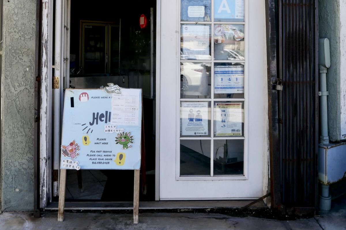 door of a small shop with a signboard outside