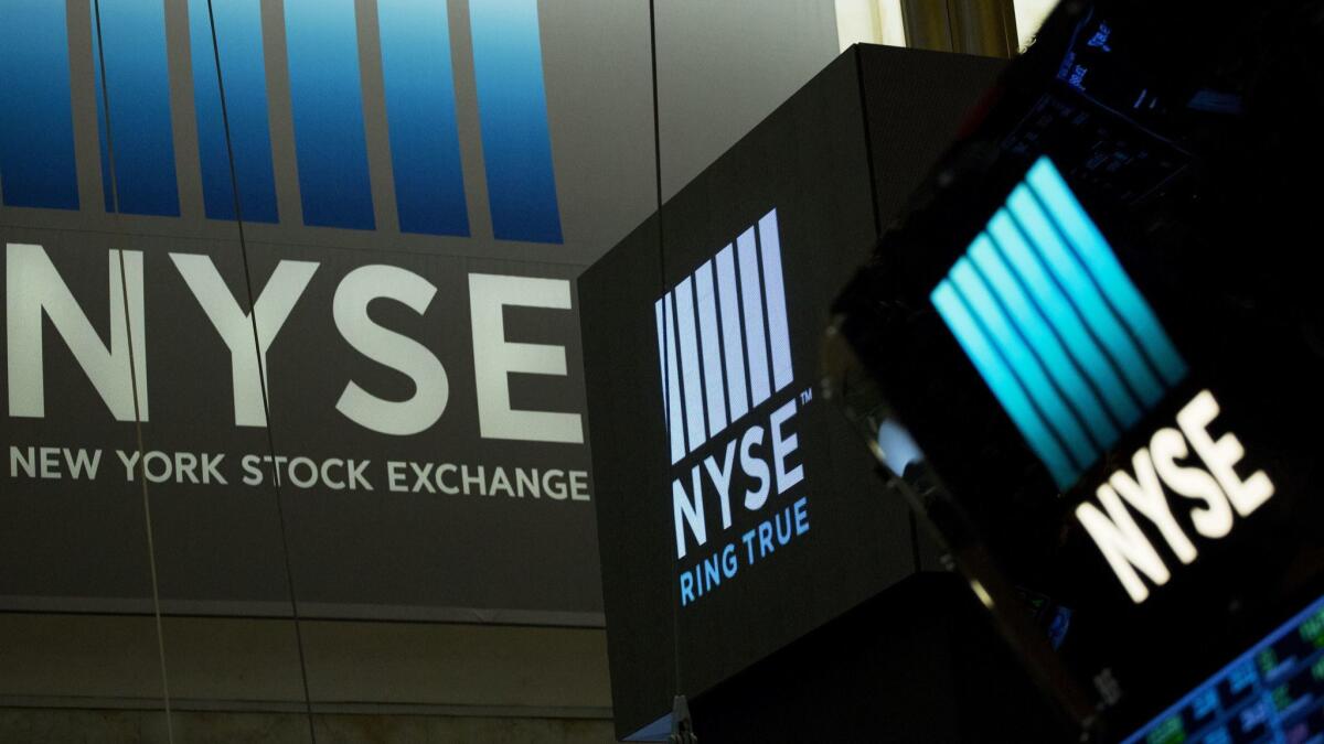 Signs for the New York Stock Exchange hang above the trading floor.