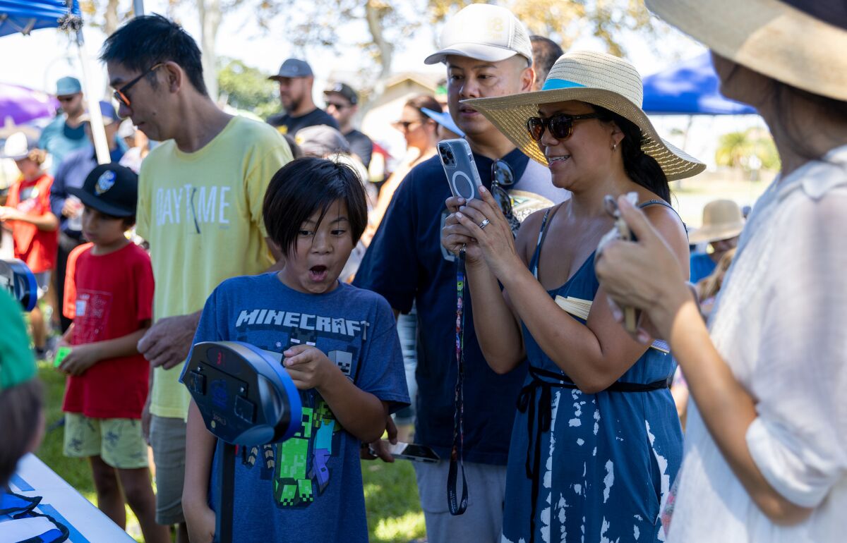 Marikarr Arrogante cheers as her son Jaiden Arrogante solves a Rubik's Cube in 40 seconds at Los Alamos Park on Saturday.