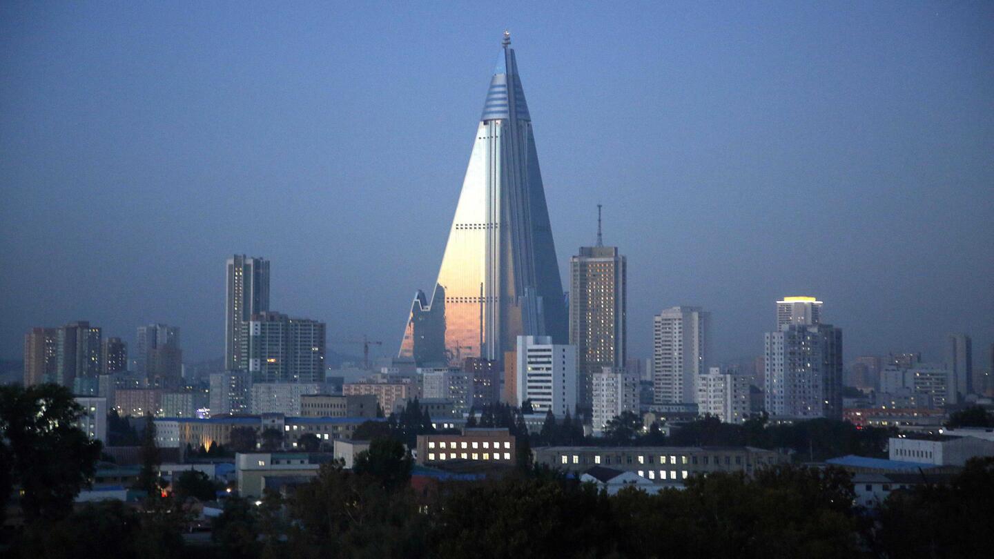 Dusk settles over Pyongyang, North Korea, as the 105-story pyramid-shaped Ryugyong Hotel towers over residential apartments. The landmark has been under construction since 1987 and was intended to be a symbol of progress and prosperity.