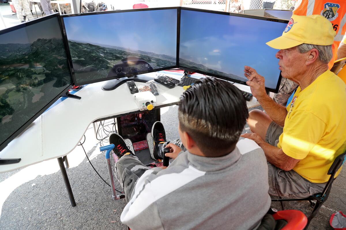Ron Allen, right, instructs Alex Arroyo in a glider flight simulation at the Civil Air Patrol's Remobilization celebration.