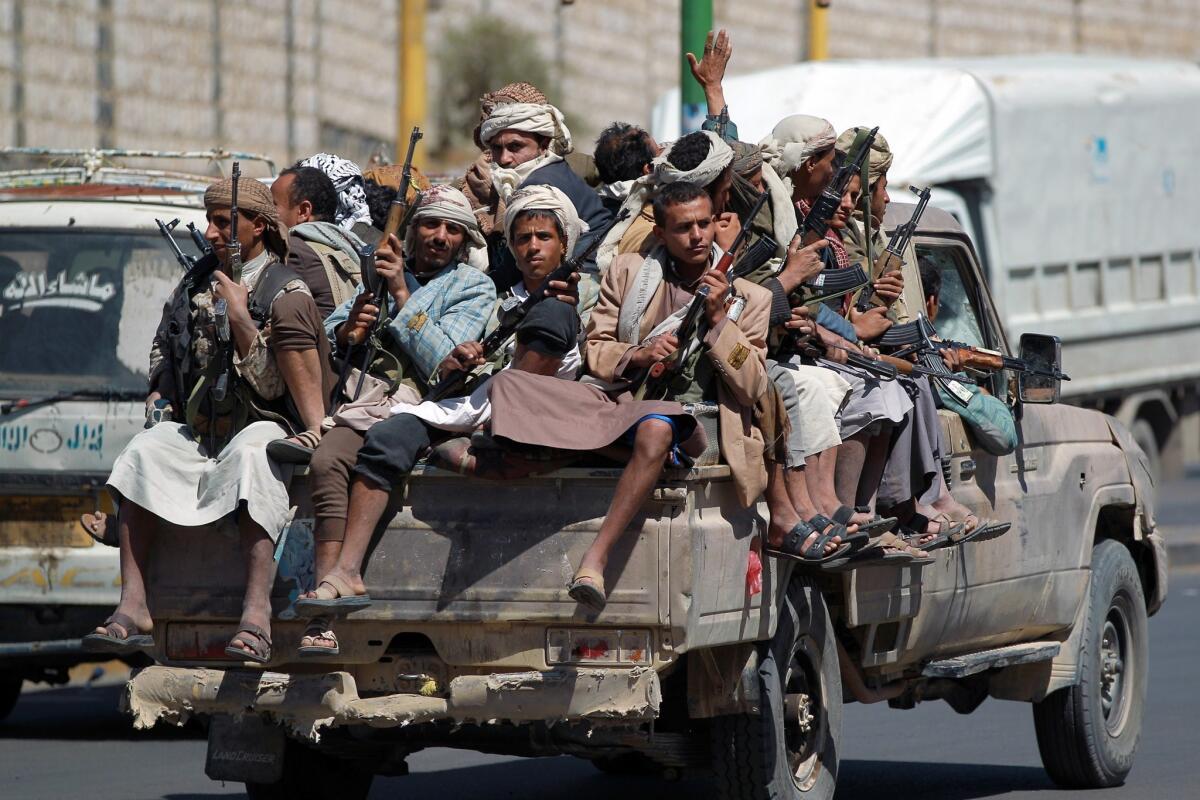 Armed Yemeni Shiite antigovernment rebels sit in the back of a pickup as they drive near the state television compound in the capital, Sanaa, on Sept. 21.