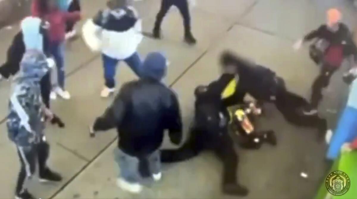 A blurry image of a policeman wrestling with a man on a sidewalk