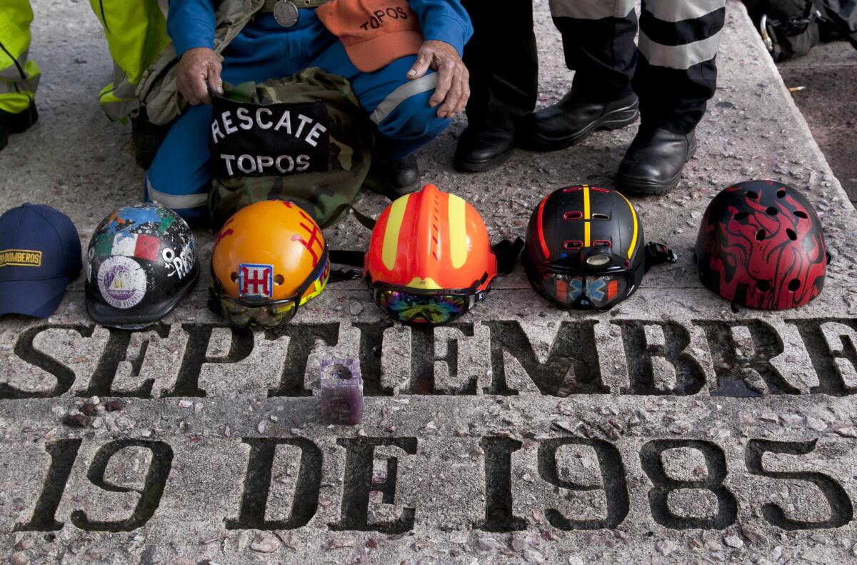 Rescue workers' hats sit on a memorial honoring those who died in the 1985 earthquake on the 30th anniversary in Mexico City.