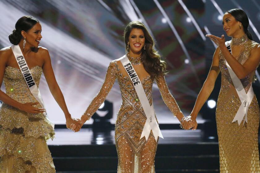 Miss France Iris Mittenaere, center, holds hands with Miss Colombia Andrea Tovar, left, and Miss Haiti Raquel Pelissier before the the Miss Universe is announced.