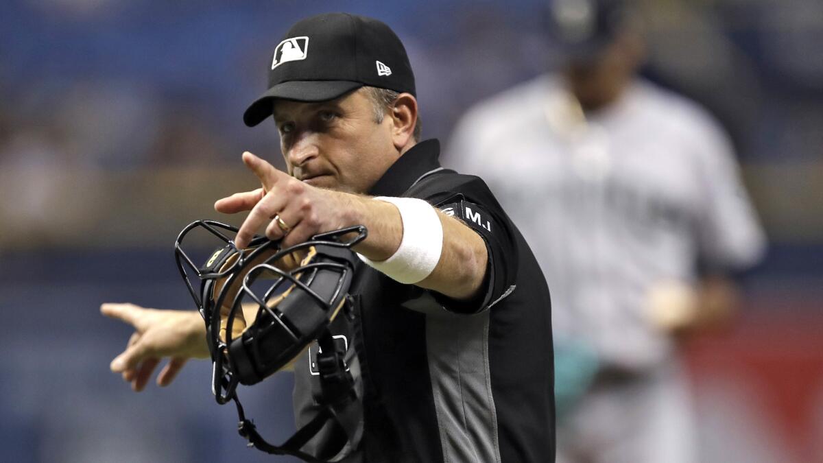 Home plate umpire Chris Guccione points at Tampa Bay Rays' Kevin Kiermaier during a baseball game against the Seattle Mariners in 2017. Sports officials are sidelined during the sports stoppage.
