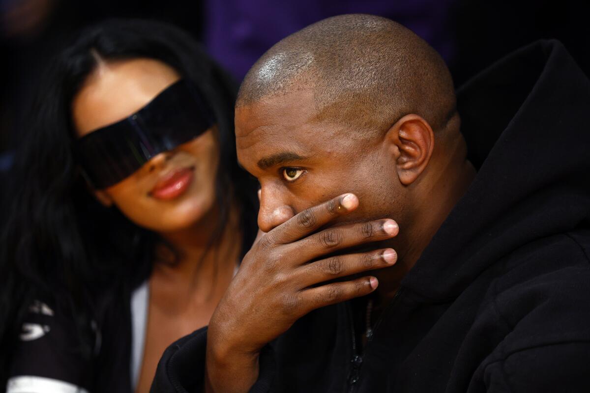 A man and woman sitting at a Lakers game