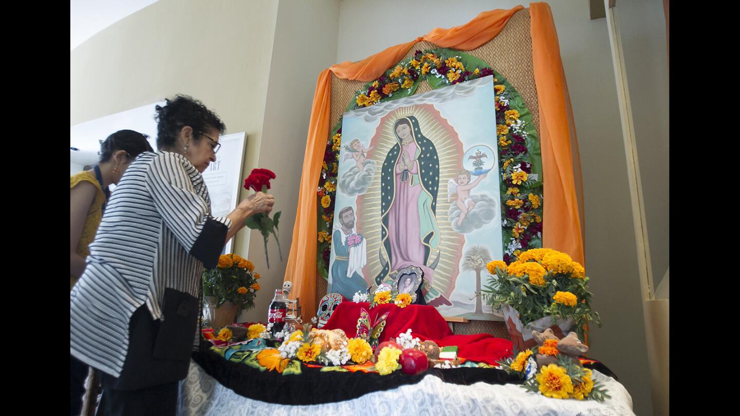 Program director Genevieve Southgate builds a memorial altar, or ofrenda, in honor of the Dia de los Muertos festival at the Bowers Museum in Santa Ana.