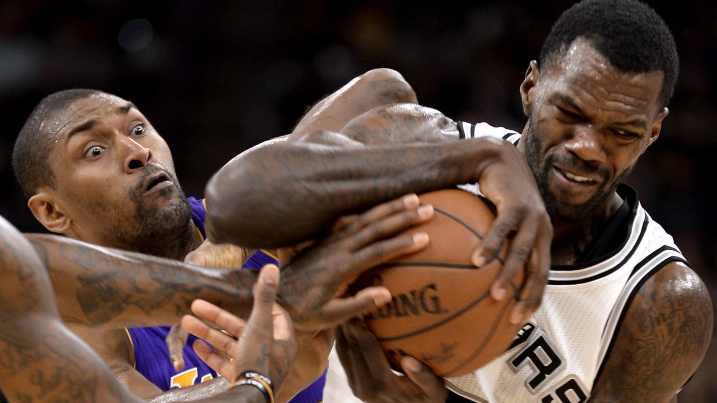 Lakers forward Metta World Peace, left, battles Spurs center Dewayne Dedmon for a rebound during the second half.