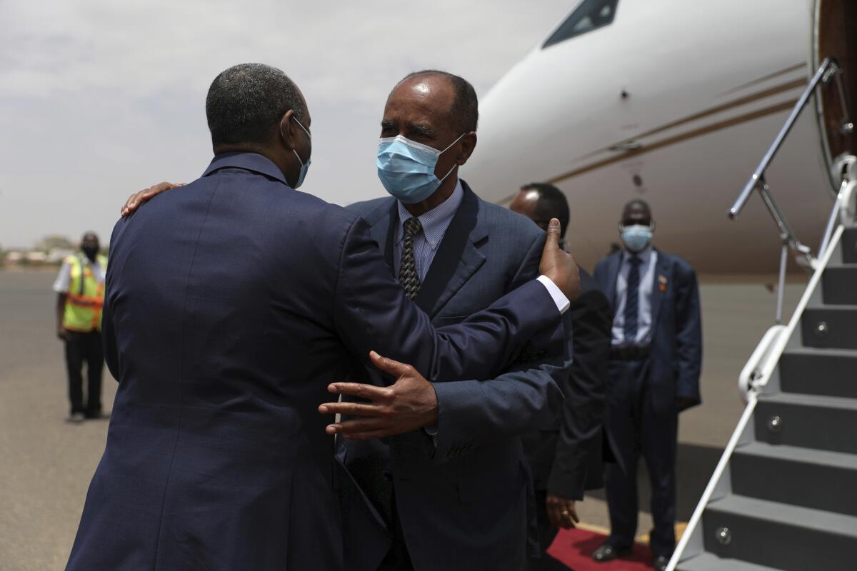 President of the Sudanese Transitional Council General Abdel Fattah al-Burhan, left, greets Eritrean President Isaias Afwerki at the Khartoum airport in Khartoum, Sudan, Tuesday, May 4, 2021. Eritrea’s president arrived in Khartoum on Tuesday for talks with Sudanese officials amid tensions between the two countries over the Tigray conflict on Sudan's border. (AP Photo/Marwan Ali)