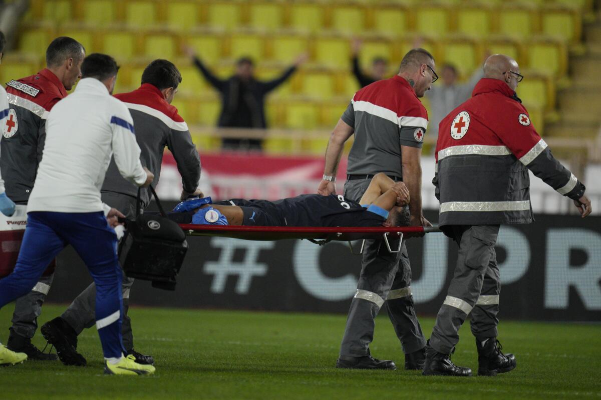 Medical staff carry Marseille's Amine Harit out to the pitch during the French League One soccer match between Monaco and Marseille at the Stade Louis II in Monaco, Sunday, Nov. 13, 2022. (AP Photo/Daniel Cole)