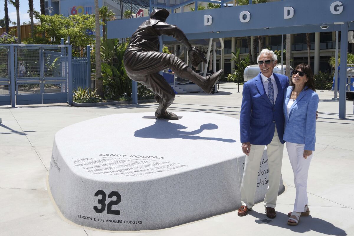 Sandy Koufax and wife Jane Purucker Clarke pose next to the statue of Koufax at Dodger Stadium on Saturday.