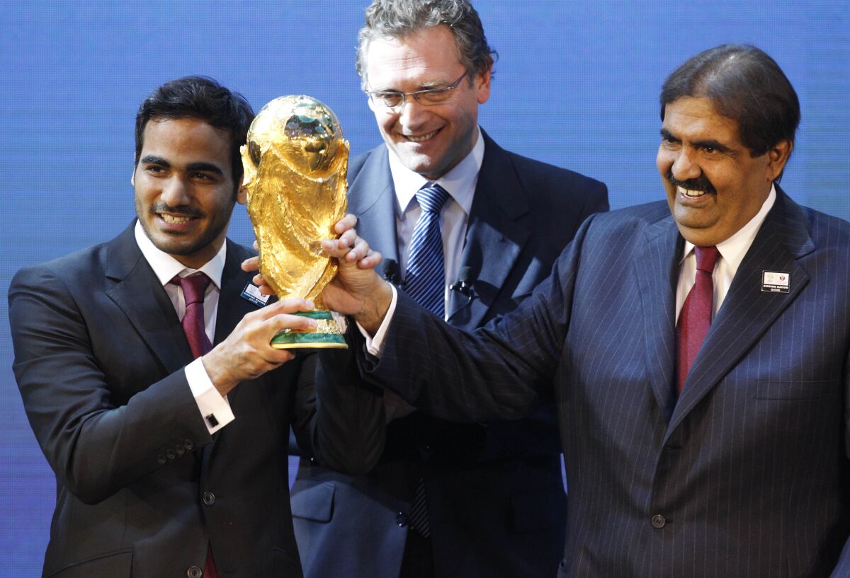 Three men hold World Cup trophy