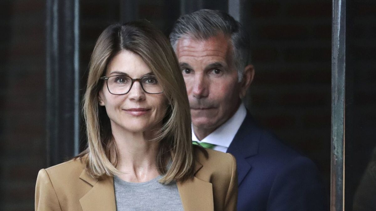 Actress Lori Loughlin, front, and husband, clothing designer Mossimo Giannulli, rear, depart federal court in Boston on Wednesday, April 3, 2019, after facing charges in a nationwide college admissions bribery scandal. (AP Photo/Charles Krupa)