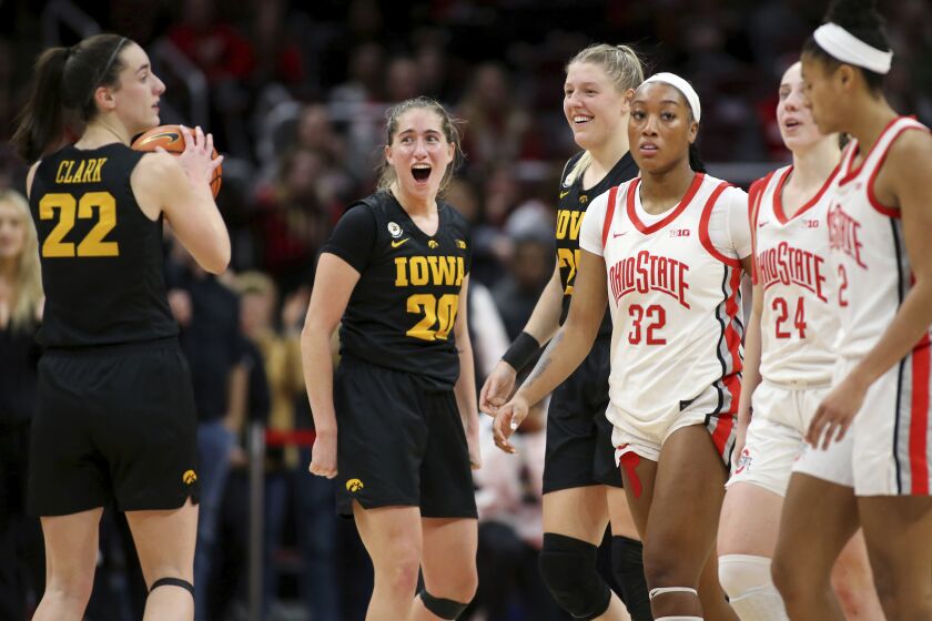 Iowa guard Kate Martin, center, celebrates with forward Monika Czinano, fourth from right, and Caitlin Clark, left, as time winds down in a win over Ohio State in an NCAA college basketball game at Value City Arena in Columbus, Ohio, Monday, Jan. 23, 2023. (AP Photo/Joe Maiorana)