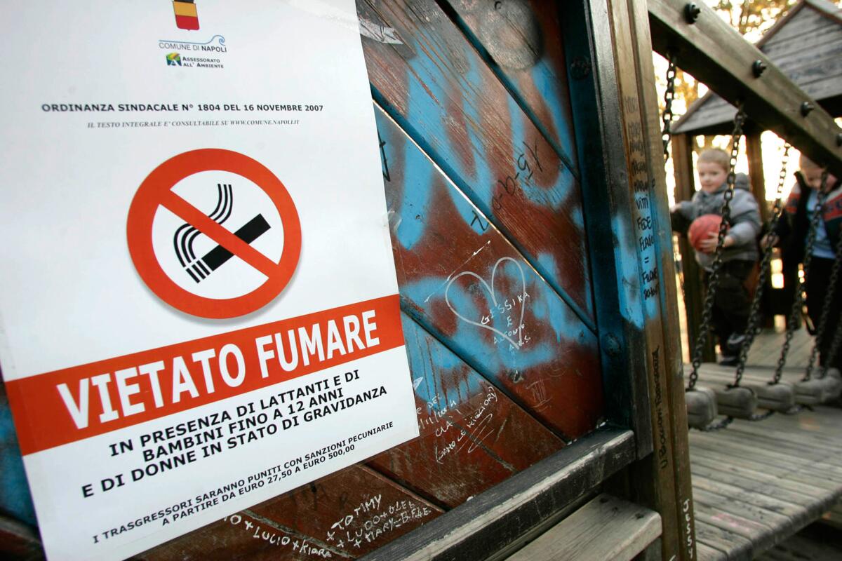 ARCHIVO - Anuncio que prohíbe fumar "en presencia de bebés y niños menors de 12 años y de mujeres embarazadas" colocado en un parque de juegos infantiles en Nápoles, en el sur de Italia, en esta fotografía de archivo.