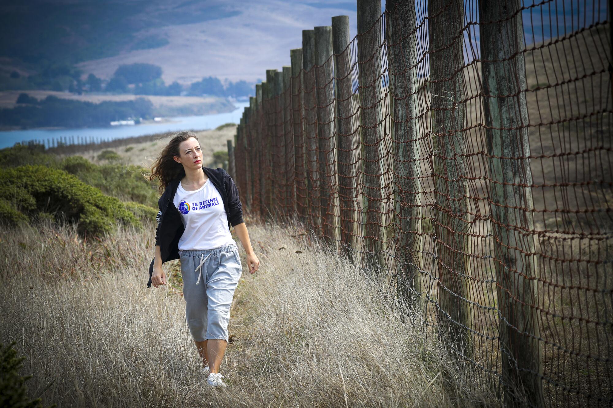 Fleur Dawes walks along a fence in the Point Reyes National Seashore. 