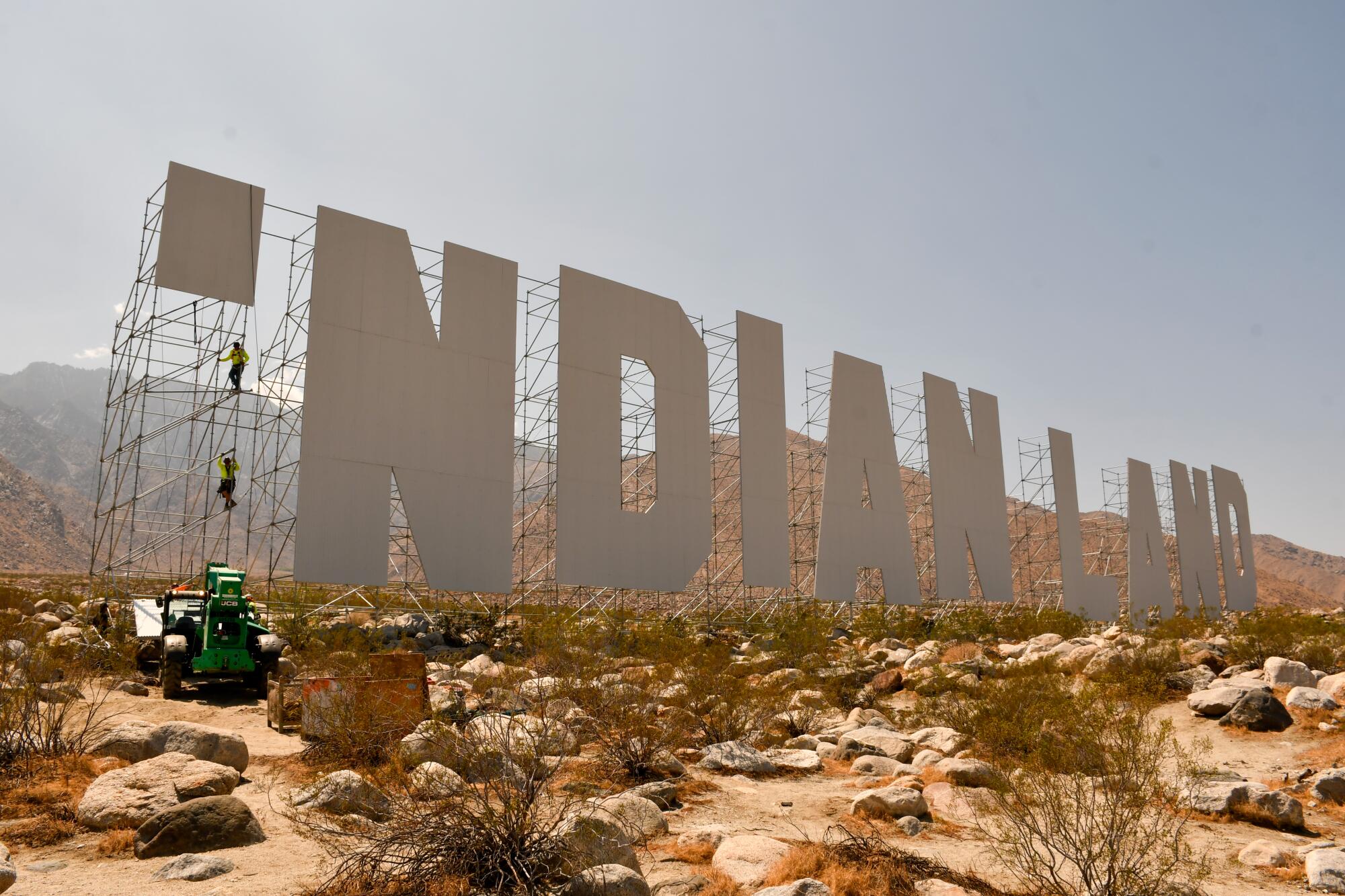 A giant sign reading "Indian Land" held up by scaffolding