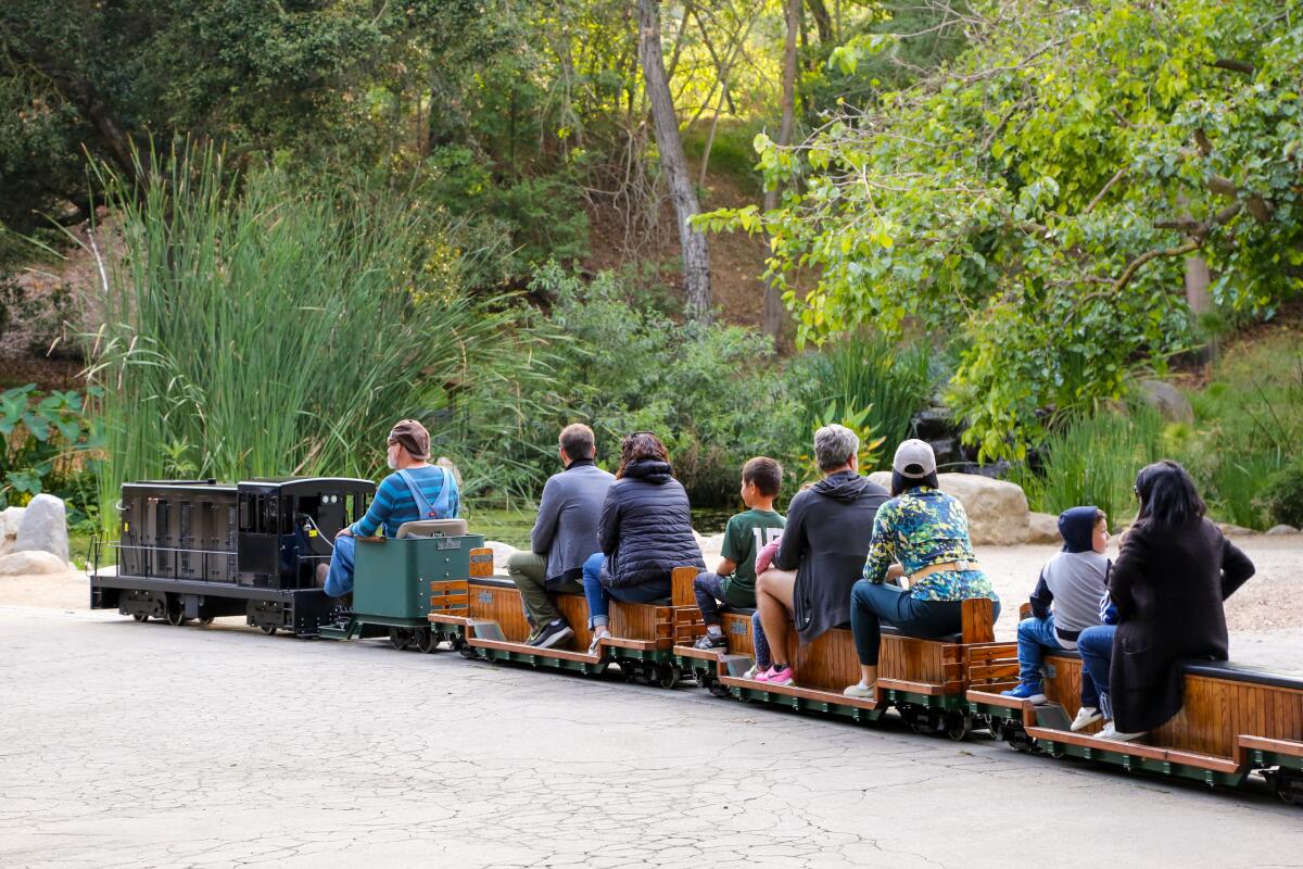 People ride the new electric train at Descanso Gardens.