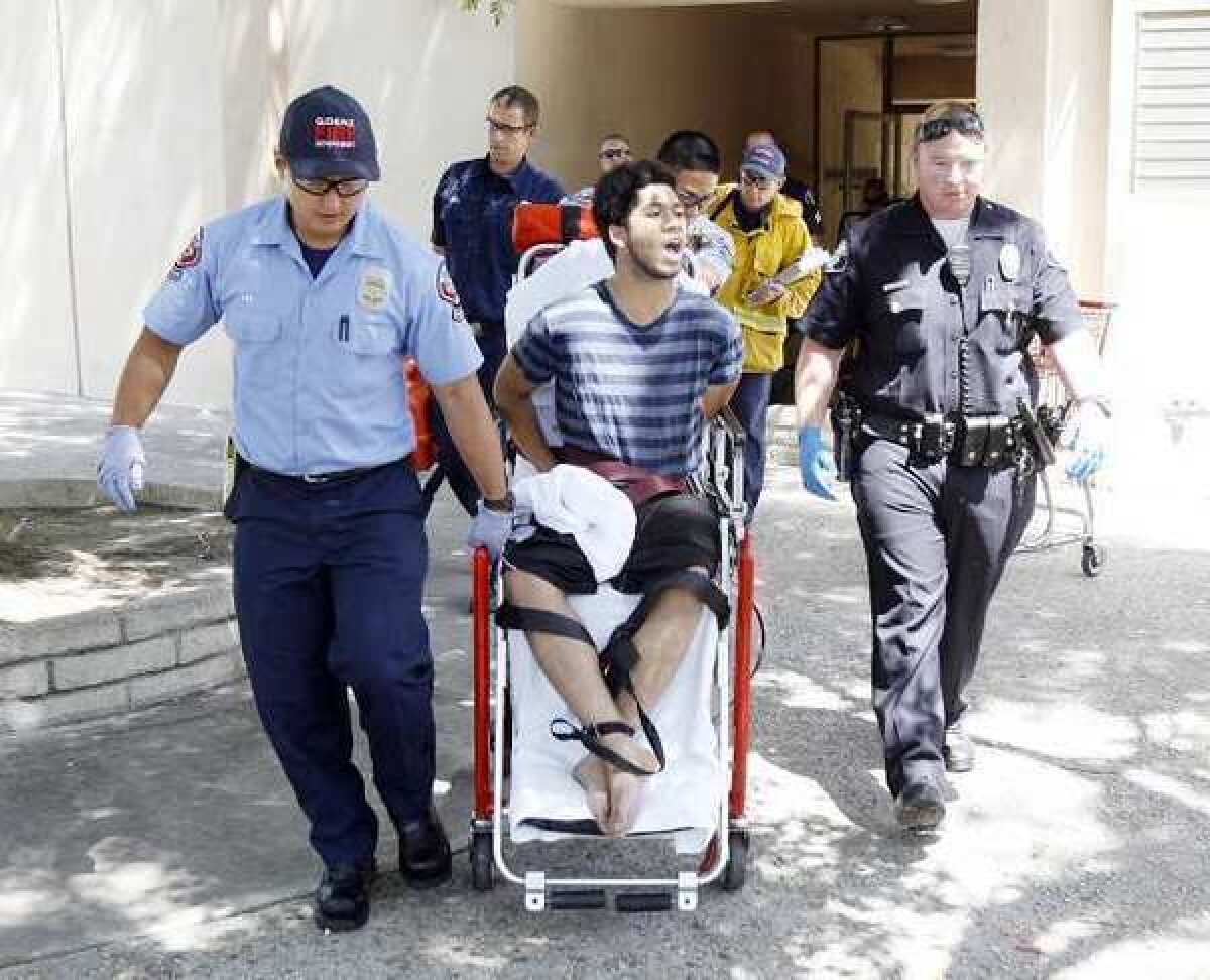 Robert William White, tied and handcuffed on a stair chair, yells the word of God to onlookers as he is wheeled out of an apartment he barricaded himself in after allegedly assaulting a 77-year-old woman with a shovel on Spazier Avenue.