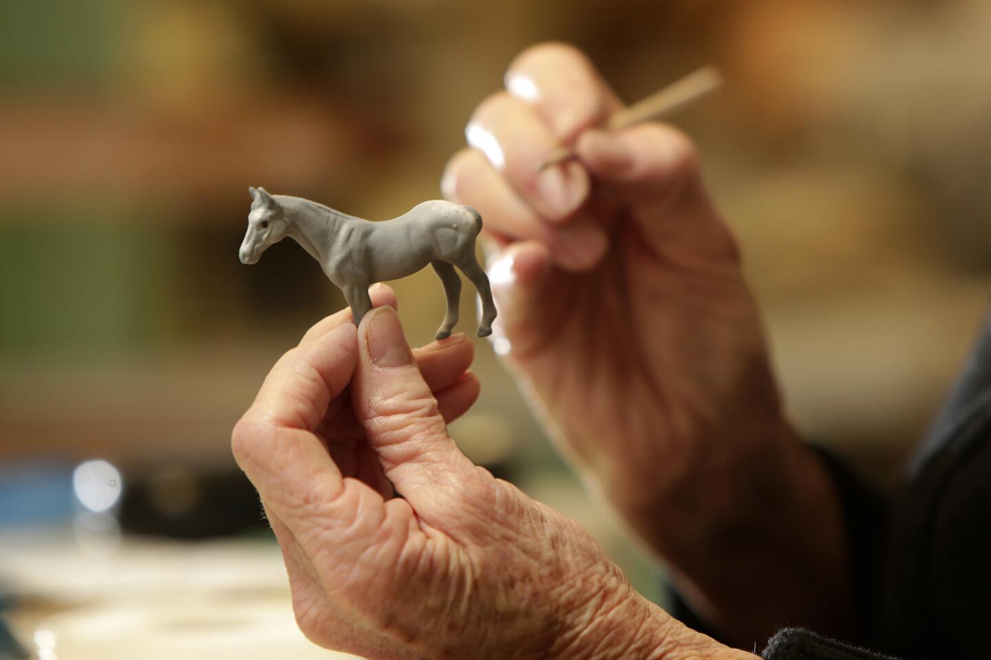 Susan Renaker Nikas, who owns and manages Hagen-Renaker, paints a horse figurine.