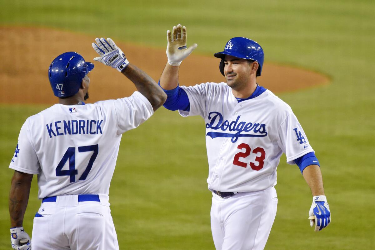 Dodgers first baseman Adrian Gonzalez (23) is congratulated by Howie Kendrick after hitting a solo home run during the first inning on Sept. 21.