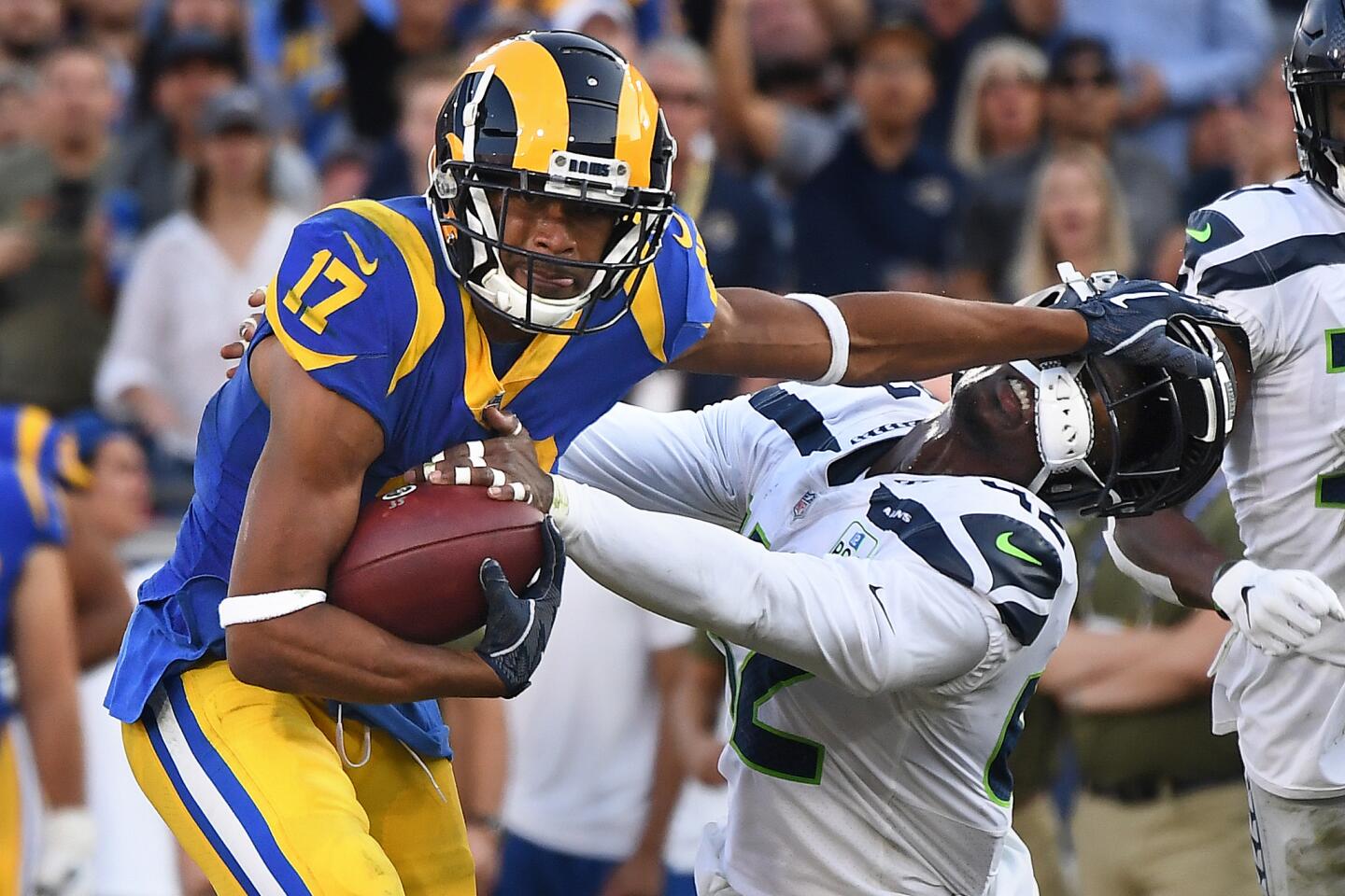 Rams receiver Robert Woods stiff-arms Seattle Seahawks safety Delano Hill to pick up yards in the third quarter at the Coliseum on Sunday.