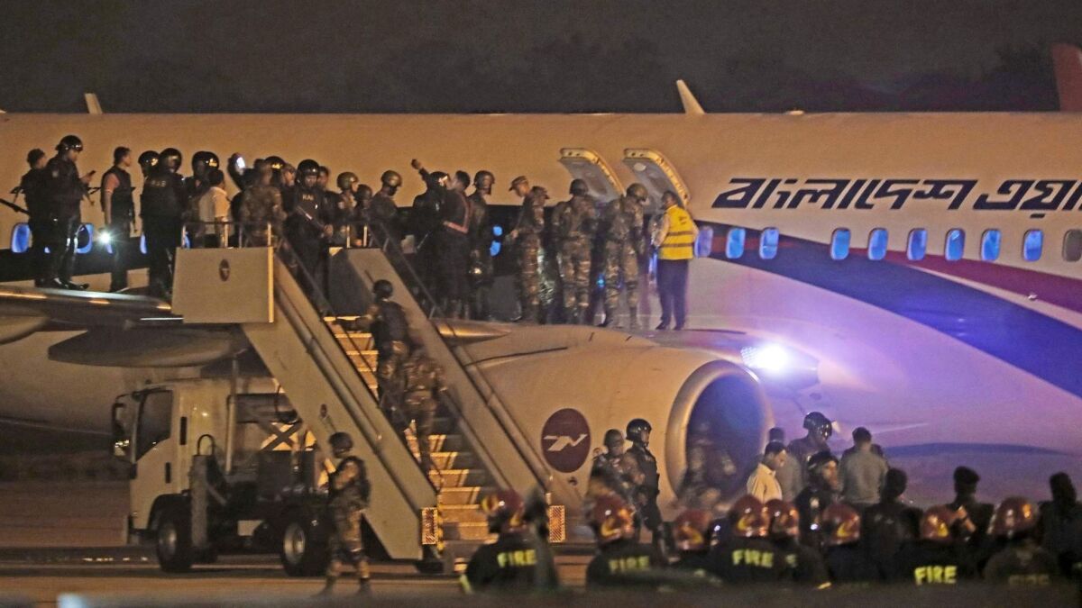 Bangladeshi security personnel stand guard at the airport in Chittagong on Sunday, following a Dubai-bound plane's emergency landing after a hijacking attempt.