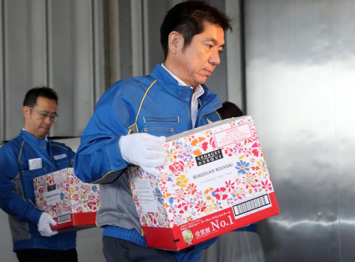 Freight company employees carry boxes of 2015 Beaujolais Nouveau wine into a customs office Oct. 31 in Tokyo.