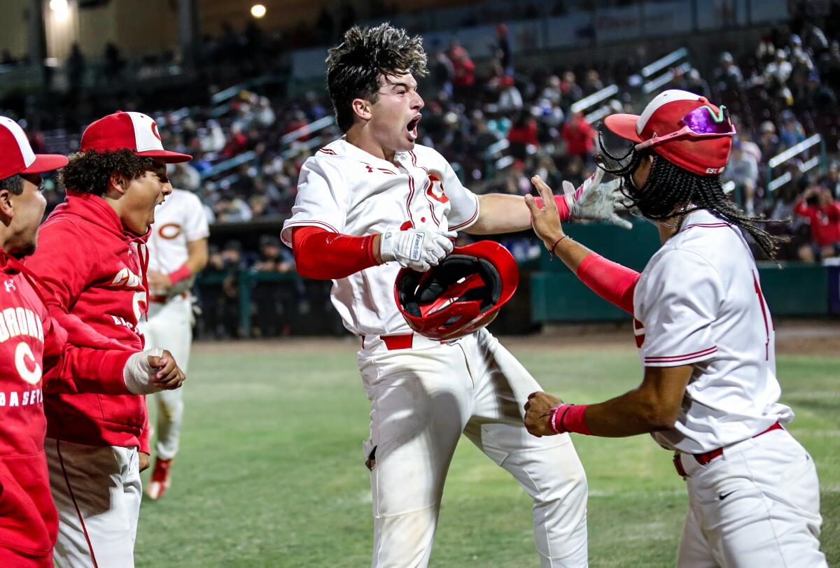 Corona High's Sam Burgess celebrates his three-run home run in the Division 1 final with teammates.