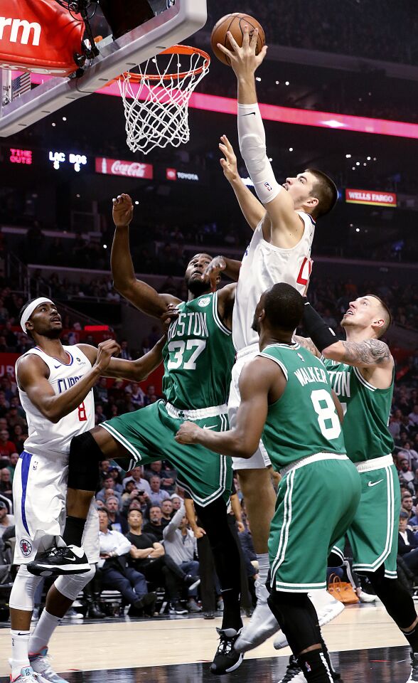 Clippers center Ivaca Zubac goes hard to the basket against a trio of Celtics defenders during the second quarter of a game Nov. 20 at Staples Center.