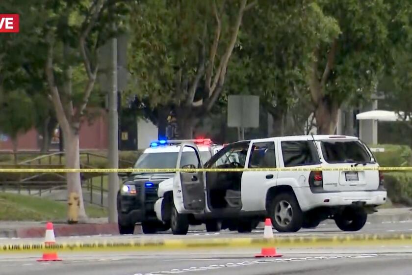 A suspect's vehicle is seen with the door opened after an L.A. County Sheriff's deputy-involved shooting in Bell Gardens