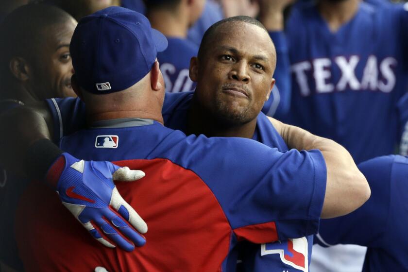 Texas Rangers' Adrian Beltre, center, receives hugs in the dugout after hitting a three-run home run off a pitch from Los Angeles Angels' Ricky Nolasco in the second inning of a baseball game, Friday, July 7, 2017, in Arlington, Texas. The hit was Beltre's 2977th career hit. (AP Photo/Tony Gutierrez)
