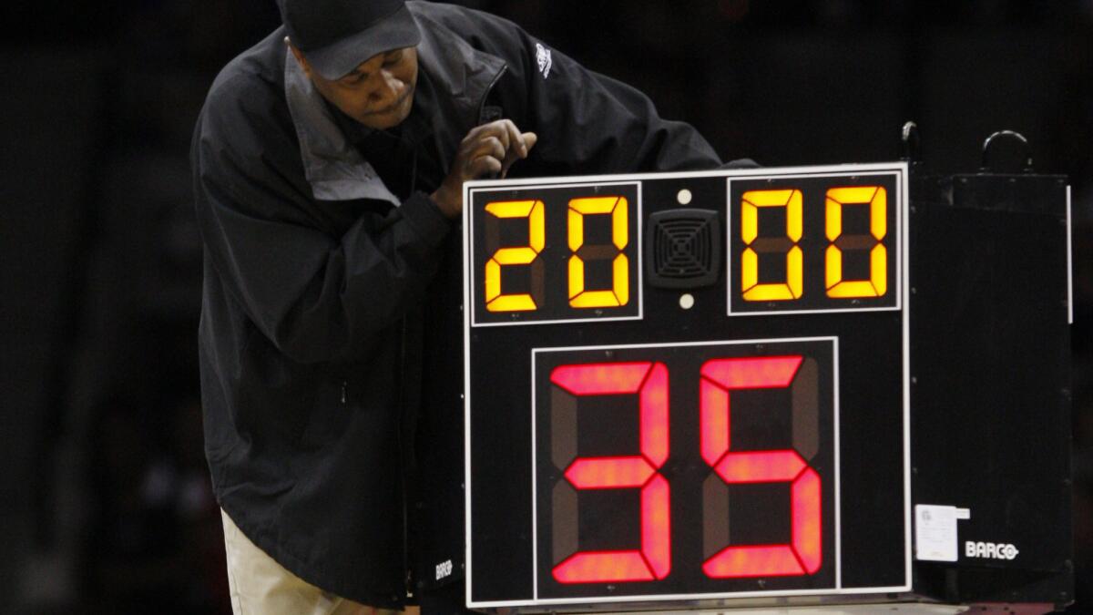 A technician adjusts a shot clock during an NCAA tournament game in Jacksonville, Fla., in 2010. The NCAA Playing Rules Oversight Panel set new rules for men's college basketball on June 8, including reducing the shot clock from 35 seconds to 30 seconds.
