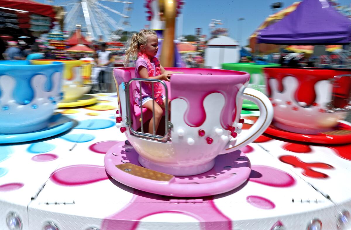 Adalyn Brizendine spins around on the tea cups ride at the Orange County Fair in Costa Mesa on July 20, 2019.