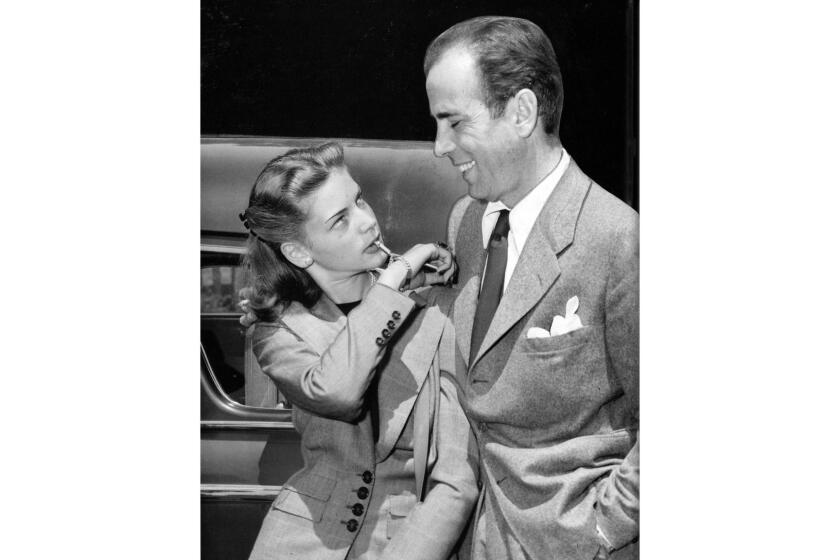May 25, 1945: Humphrey Bogart and Lauren Bacall at Union Station upon their return to California after wedding in Ohio. Bacall is blowing on small whistle attached to her bracelet.