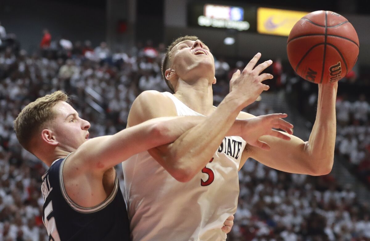 SDSU's Yanni Wetzell shoots and draws the foul by Utah State's Sam Merrill with a Wilson ball instead of the controversial Nike ball they've been using.