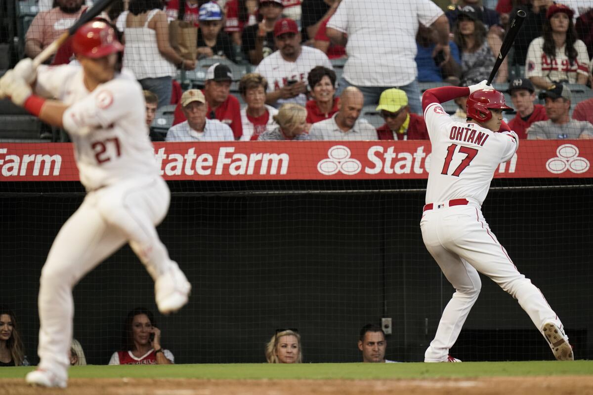 Los Angeles Angels' Shohei Ohtani, right, of Japan, prepares for his at-bat as Mike Trout stands in the batter's box during the third inning of a baseball game against the Houston Astros Tuesday, July 12, 2022, in Anaheim, Calif. (AP Photo/Jae C. Hong)