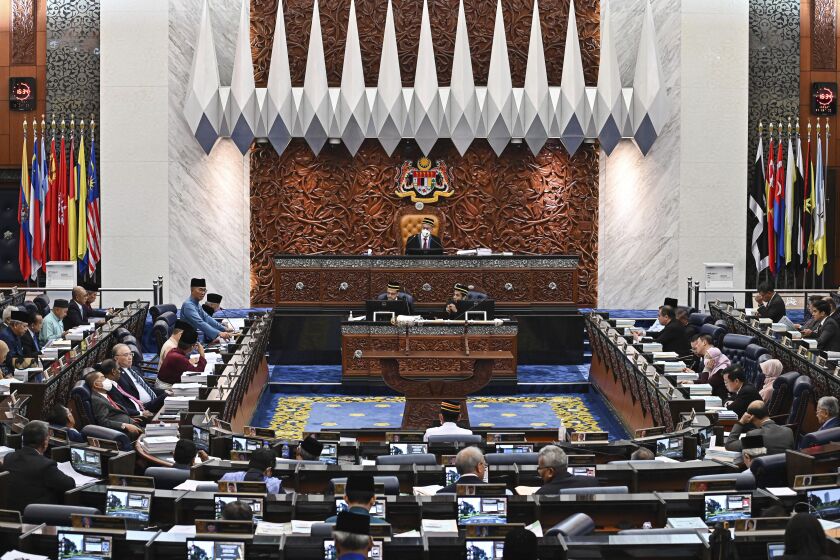 In this photo released by Malaysia's Department of Information, Malaysia's Finance Minister Zafrul Aziz, center left, delivers the 2023 budget speech at parliament in Kuala Lumpur, Malaysia, Friday, Oct. 7, 2022. (Famer Roheni/Malaysia Department of Information via AP)