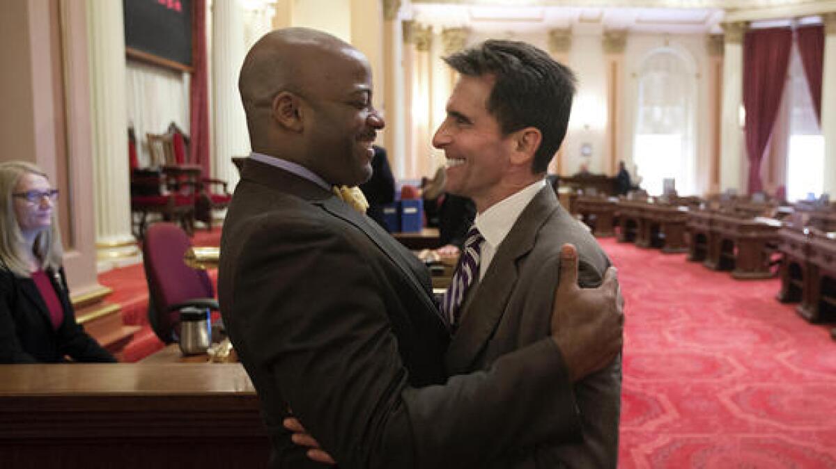 Outgoing Democratic state Sens. Isadore Hall III of Compton, left, and Mark Leno of San Francisco share a moment on the last day of the two-year legislative session.