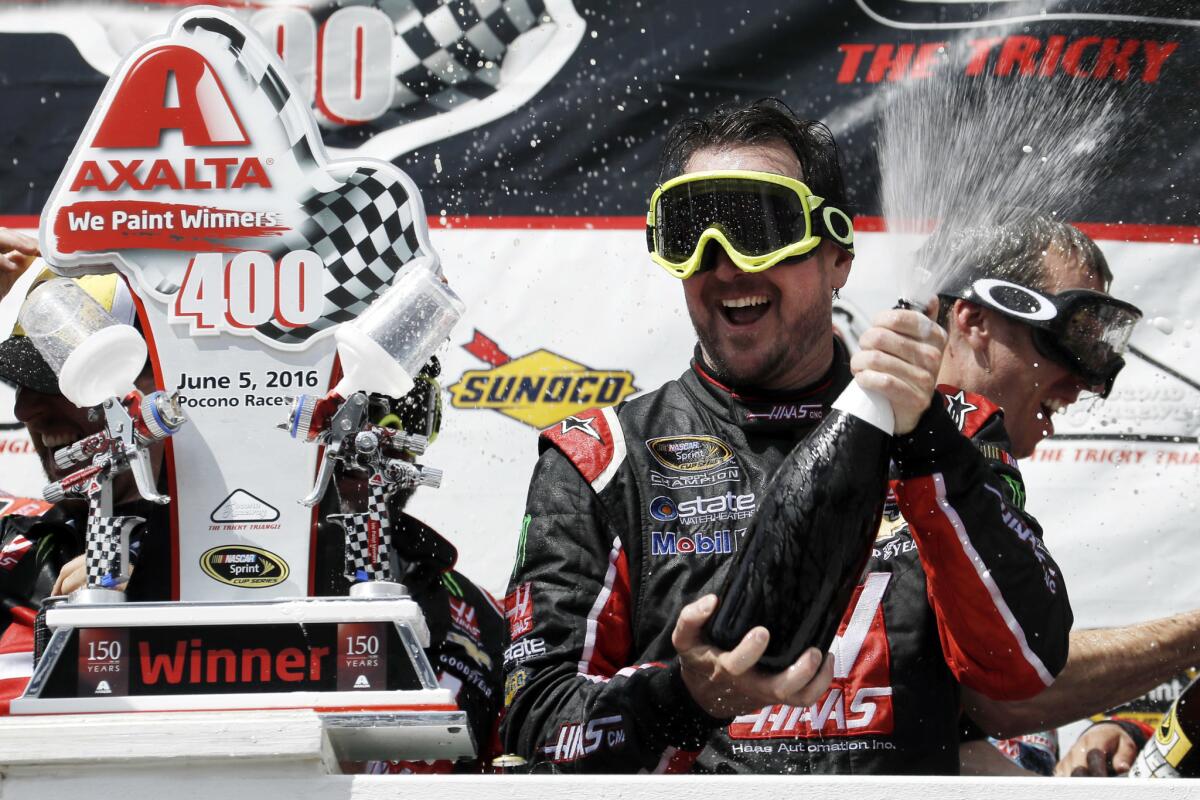 Kurt Busch celebrates with his team in Victory Lane after winning the NASCAR Sprint Cup series race at Pocono Raceway.