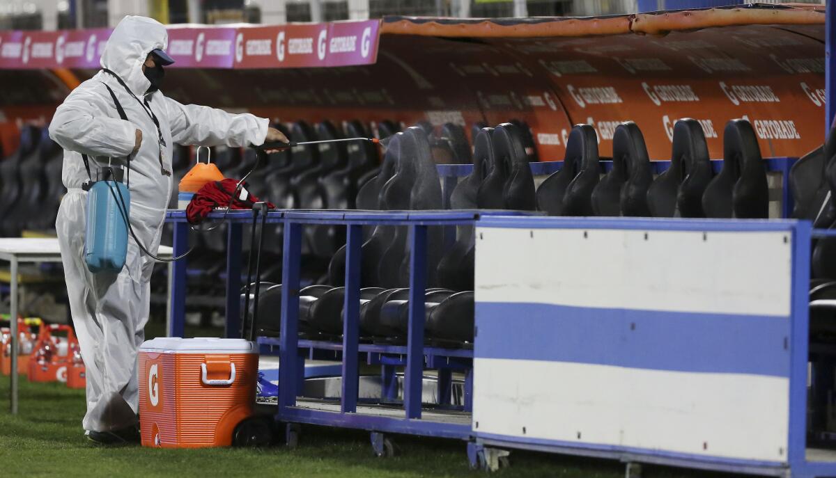 A worker disinfects the benches prior to a Copa Libertadores