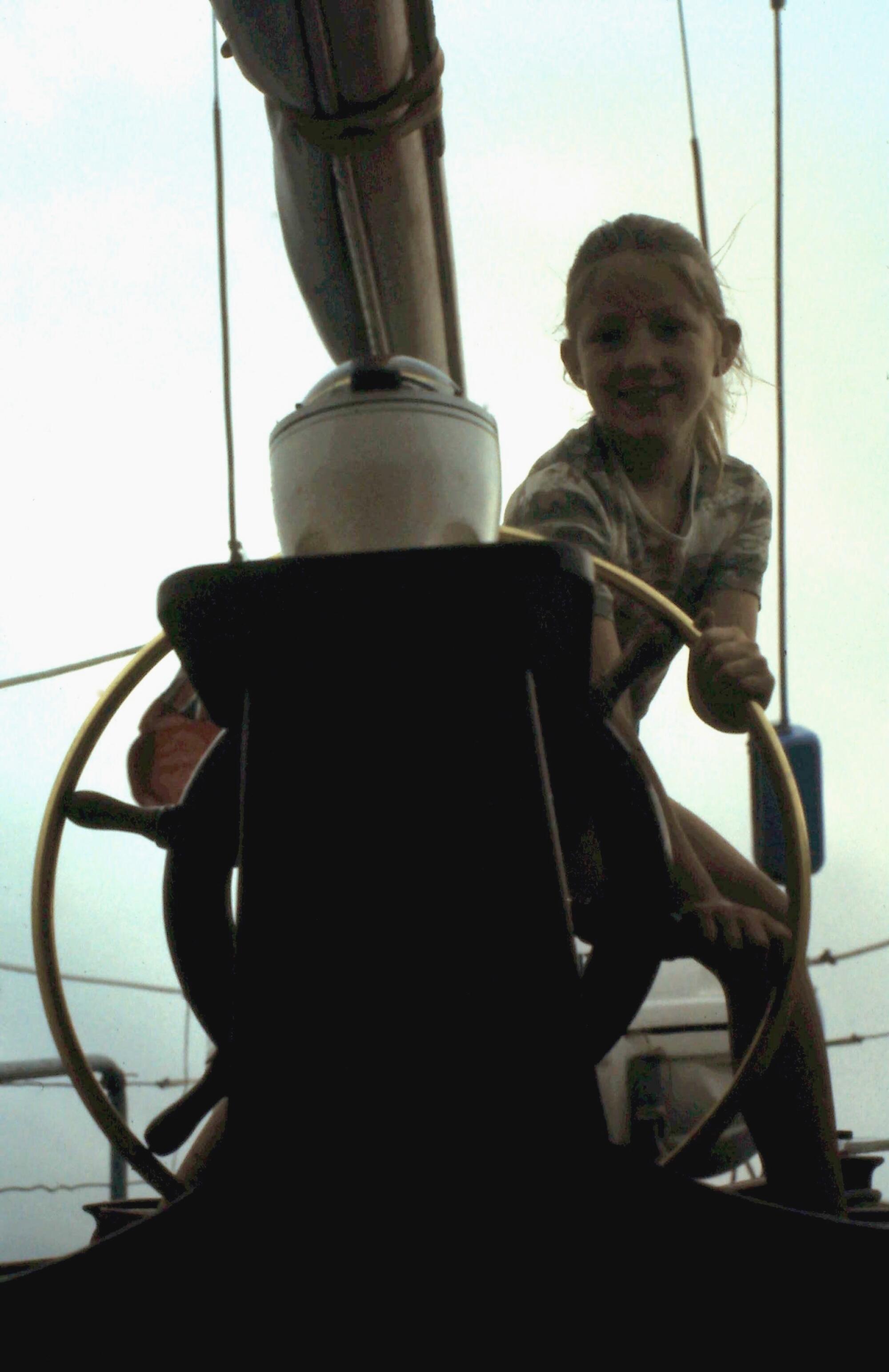 Suzanne Heywood at 8, trying her hand at steering a boat.
