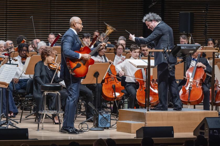 This image released by the New York Philharmonic shows former New York Yankees baseball player Bernie Williams, standing left, with conductor Gustavo Dudamel as he makes his New York Philharmonic debut in New York on Wednesday, April 24, 2024. (Brandon Patoc/New York Philharmonic via AP)