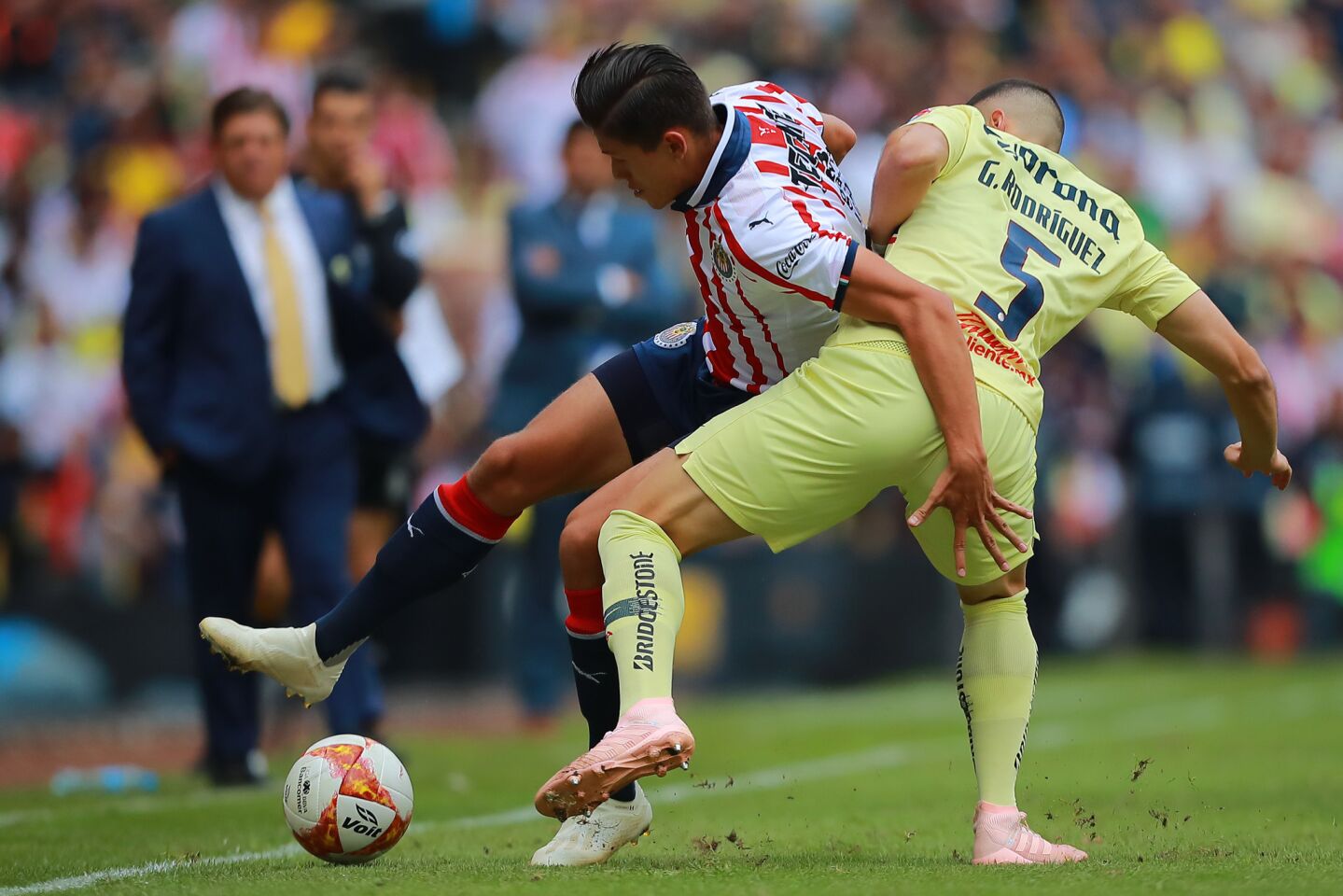 MEXICO CITY, MEXICO - SEPTEMBER 30: Jose Godinez #23 of Chivas struggles for the ball with Guido Rodriguez #5 of America during the 11th round match between America and Chivas as part of the Torneo Apertura 2018 Liga MX at Azteca Stadium on September 30, 2018 in Mexico City, Mexico.