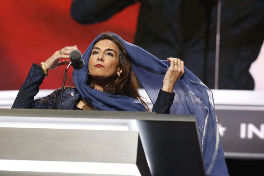 Harmeet Dhillon covers her hair as she conducts the invocation during the second day of the Republican National Convention in Cleveland, Tuesday, July 19, 2016.