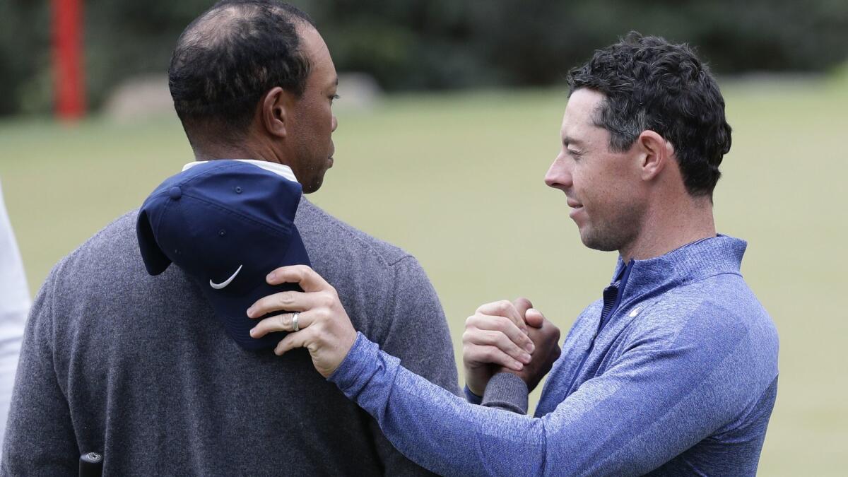 Tiger Woods is congratulated by Rory McIlroy after winning their Match Play meeting Saturday.